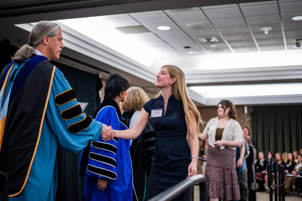 Student shaking hand with faculty 6